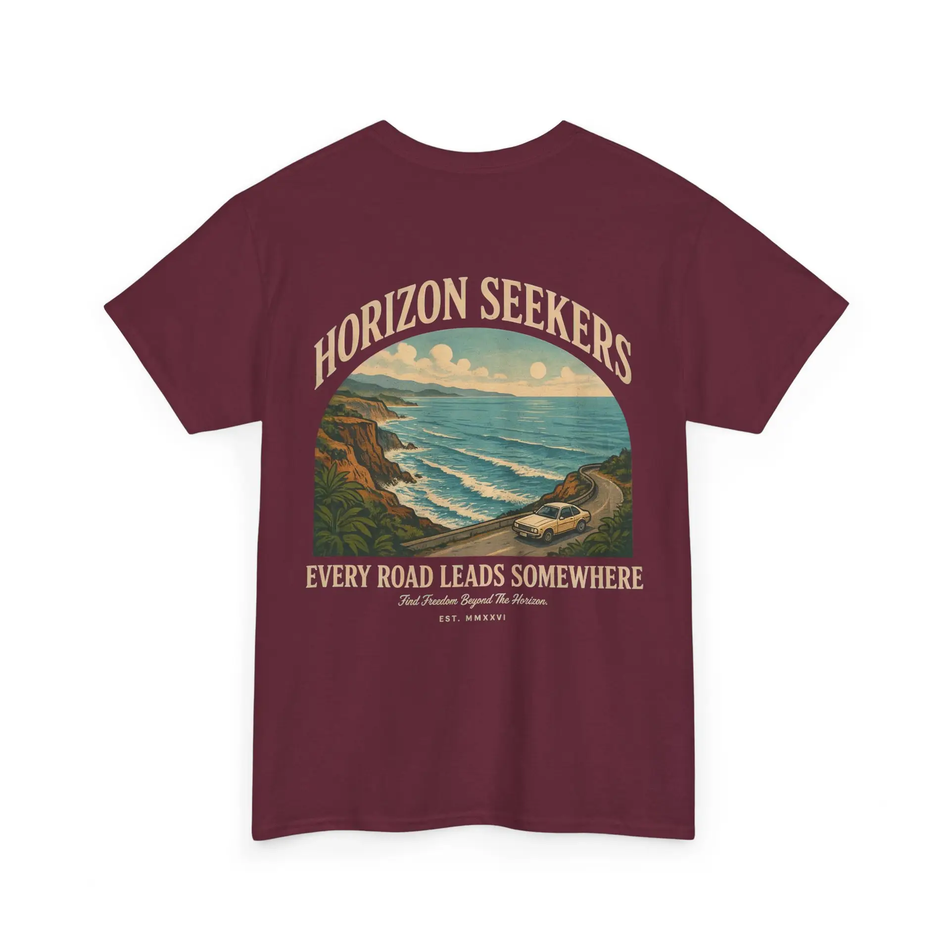 Someone wearing a blue Horizon Seekers graphic t-shirt featuring a vintage coastal road illustration with ocean cliffs, a retro car, bold typography reading "Every Road Leads Somewhere," and a nostalgic travel-inspired design in a professional studio.