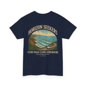 Someone wearing a blue Horizon Seekers graphic t-shirt featuring a vintage coastal road illustration with ocean cliffs, a retro car, bold typography reading "Every Road Leads Somewhere," and a nostalgic travel-inspired design in a professional studio.
