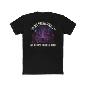 Person wearing a Night Drive Society graphic t-shirt featuring a retro-futuristic neon city skyline, rain-soaked streets, towering palm trees, and a classic car driving into the night with bold typography reading "No Destination Required" and "Lost In The Lights • Built For The After Hours," photographed in a professional studio.