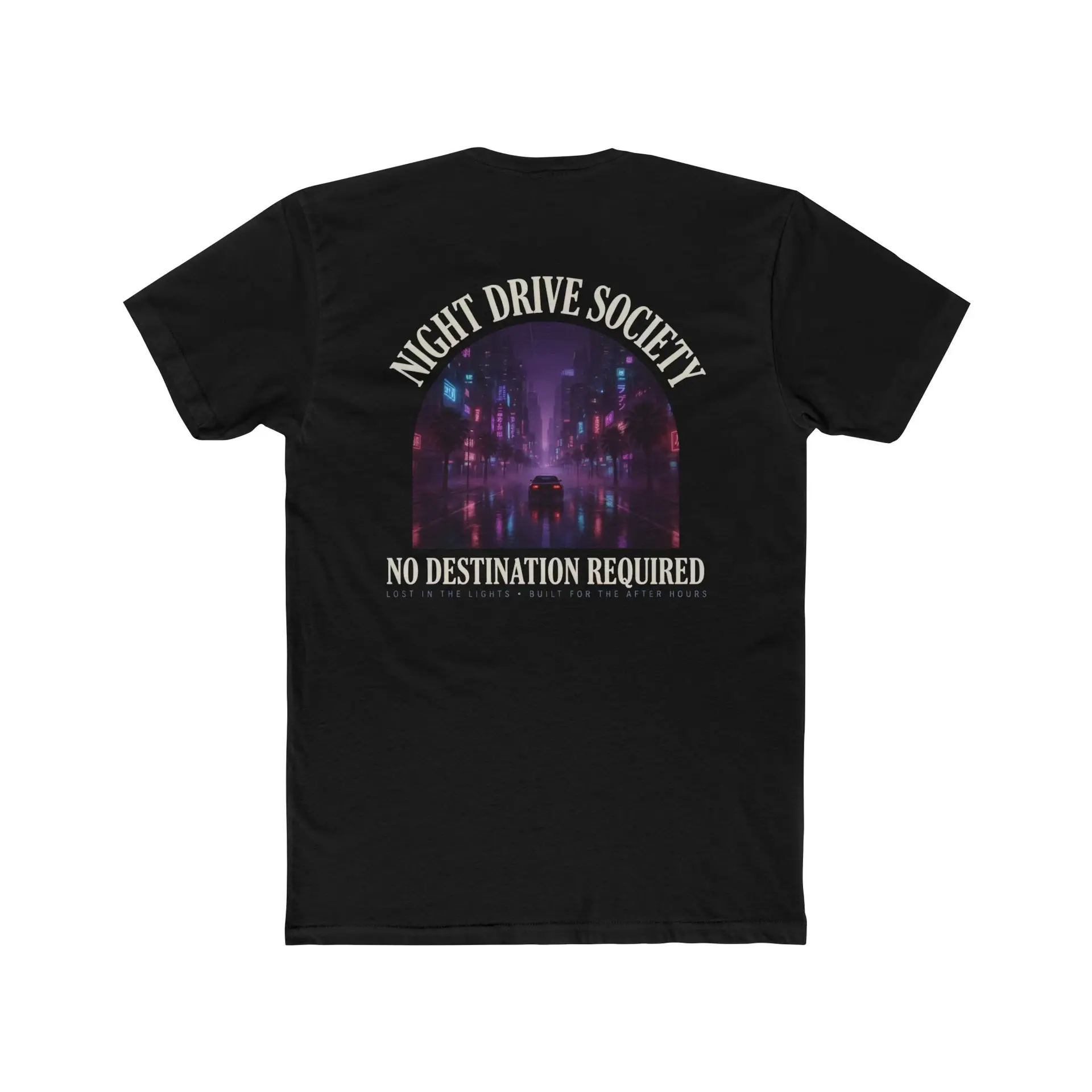 Person wearing a Night Drive Society graphic t-shirt featuring a retro-futuristic neon city skyline, rain-soaked streets, towering palm trees, and a classic car driving into the night with bold typography reading "No Destination Required" and "Lost In The Lights • Built For The After Hours," photographed in a professional studio.
