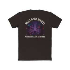 Person wearing a Night Drive Society graphic t-shirt featuring a retro-futuristic neon city skyline, rain-soaked streets, towering palm trees, and a classic car driving into the night with bold typography reading "No Destination Required" and "Lost In The Lights • Built For The After Hours," photographed in a professional studio.