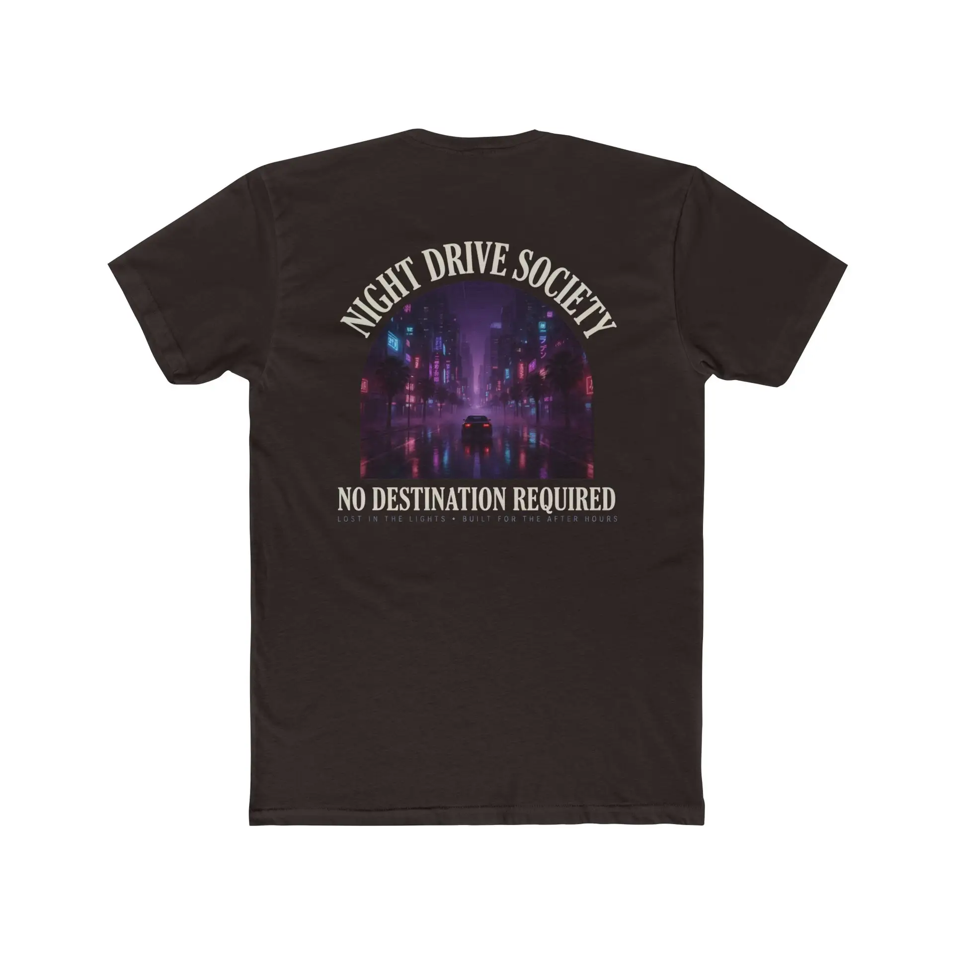 Person wearing a Night Drive Society graphic t-shirt featuring a retro-futuristic neon city skyline, rain-soaked streets, towering palm trees, and a classic car driving into the night with bold typography reading "No Destination Required" and "Lost In The Lights • Built For The After Hours," photographed in a professional studio.