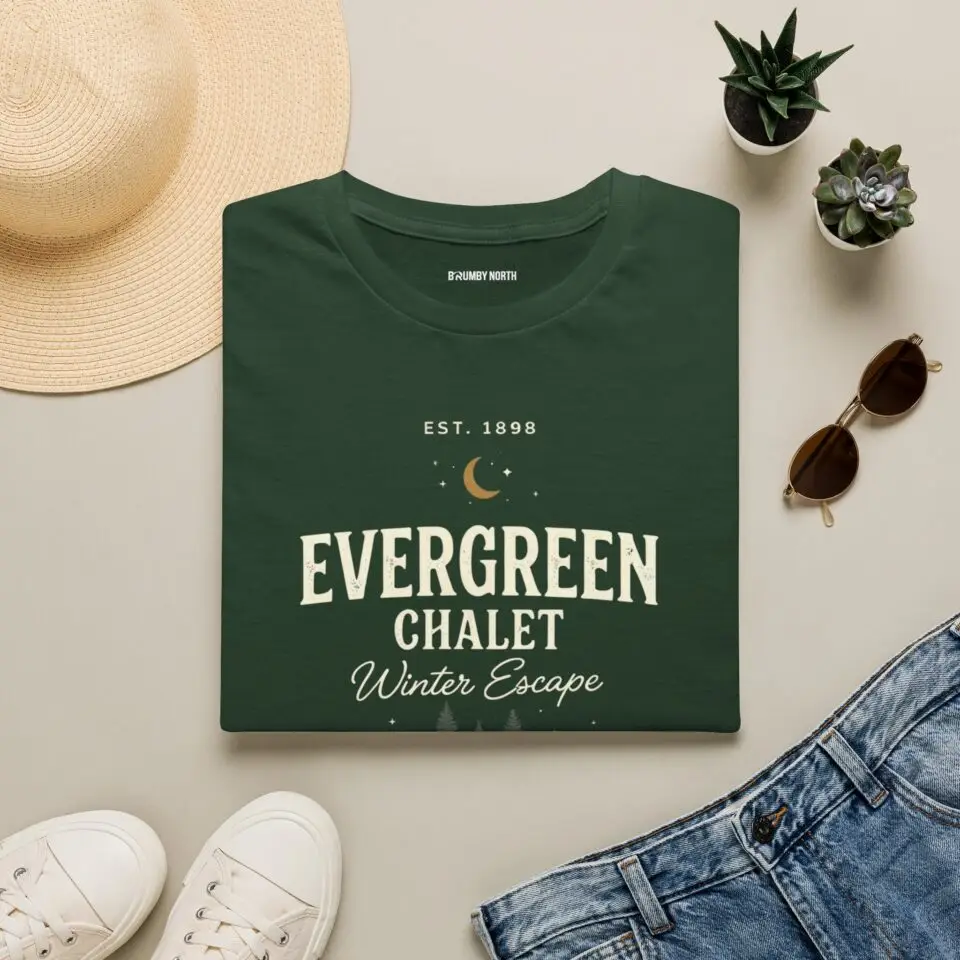 Evergreen Chalet Winter Escape Christmas graphic T-shirt on female model Forest green vintage Christmas cabin graphic tee front view Cozy winter lodge inspired unisex holiday T-shirt Evergreen Chalet Christmas shirt premium cotton graphic tee
