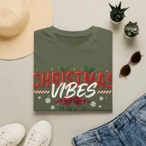 Smiling woman wearing a black Christmas Vibes Only graphic unisex t-shirt featuring festive typography, holly leaves, and snowflake accents with a Santa hat in a white studio setting.