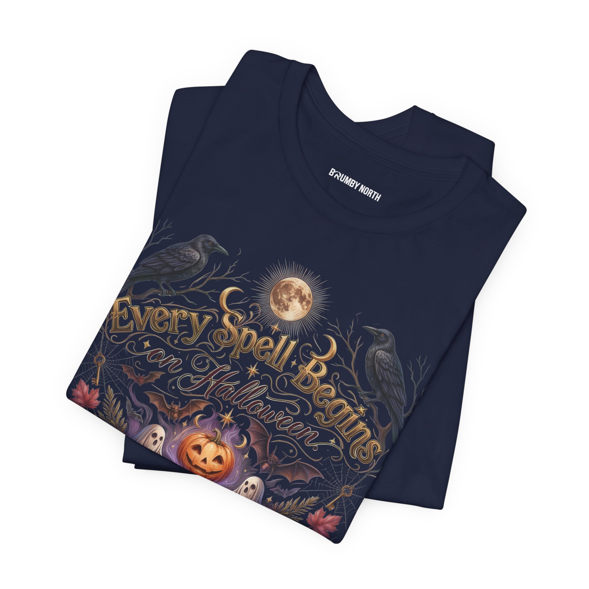Woman wearing a black Bella+Canvas Halloween graphic t-shirt featuring a vintage illustration of an enchanted spell book, pumpkin, ghosts, candles, ravens, and the phrase "Every Spell Begins on Halloween."