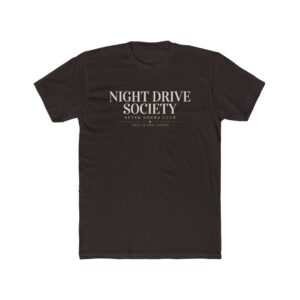 Person wearing a Night Drive Society graphic t-shirt featuring a retro-futuristic neon city skyline, rain-soaked streets, towering palm trees, and a classic car driving into the night with bold typography reading "No Destination Required" and "Lost In The Lights • Built For The After Hours," photographed in a professional studio.