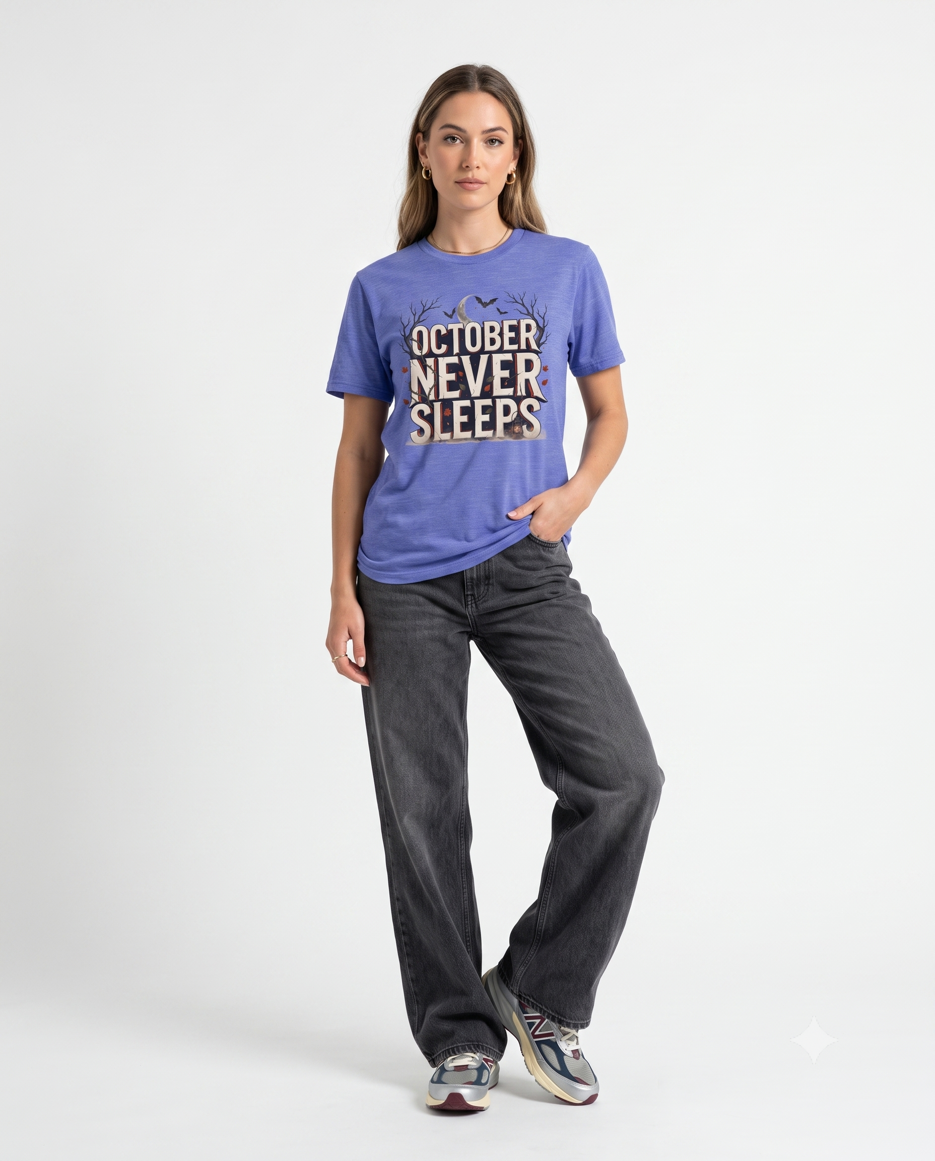 Woman wearing a purple October Never Sleeps Halloween graphic t-shirt featuring a vintage spooky typography design with moon, bats, and autumn tree silhouettes in a professional studio.