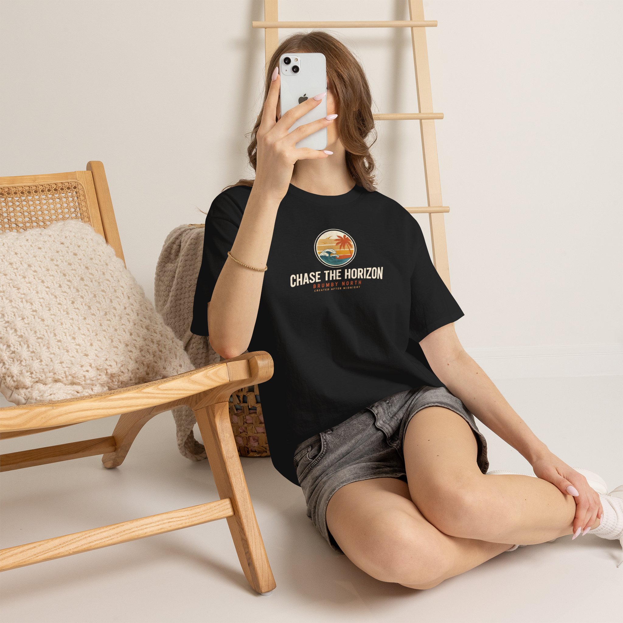Front Image Woman wearing an olive green Chase The Horizon vintage surf graphic unisex heavy cotton t-shirt featuring a retro sunset chest print in a professional studio. Back Image Back view of woman wearing an olive green Chase The Horizon vintage surf graphic t-shirt with a large retro ocean wave and sunset illustration in a studio setting