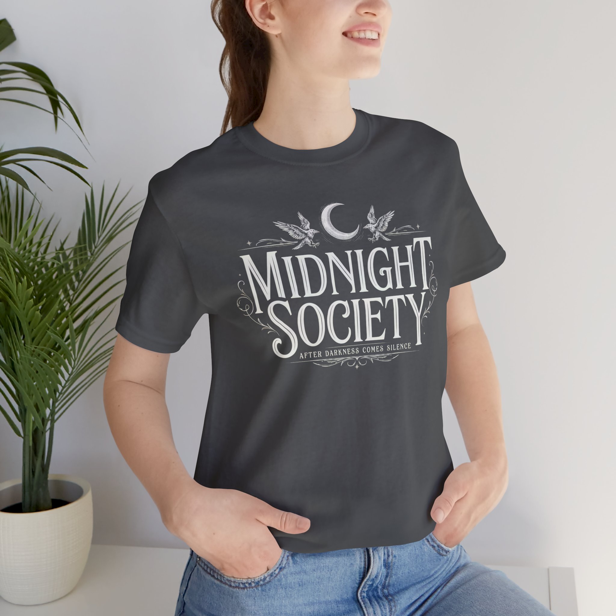 Woman wearing Midnight Society Gothic Halloween graphic t-shirt featuring vintage moon and bat front design. Bella+Canvas Midnight Society Halloween t-shirt with gothic front print on premium unisex cotton tee. Front view of Midnight Society spooky season graphic tee with moon, bats and vintage gothic typography. Premium Halloween graphic t-shirt with minimalist Midnight Society front artwork for autumn fashion