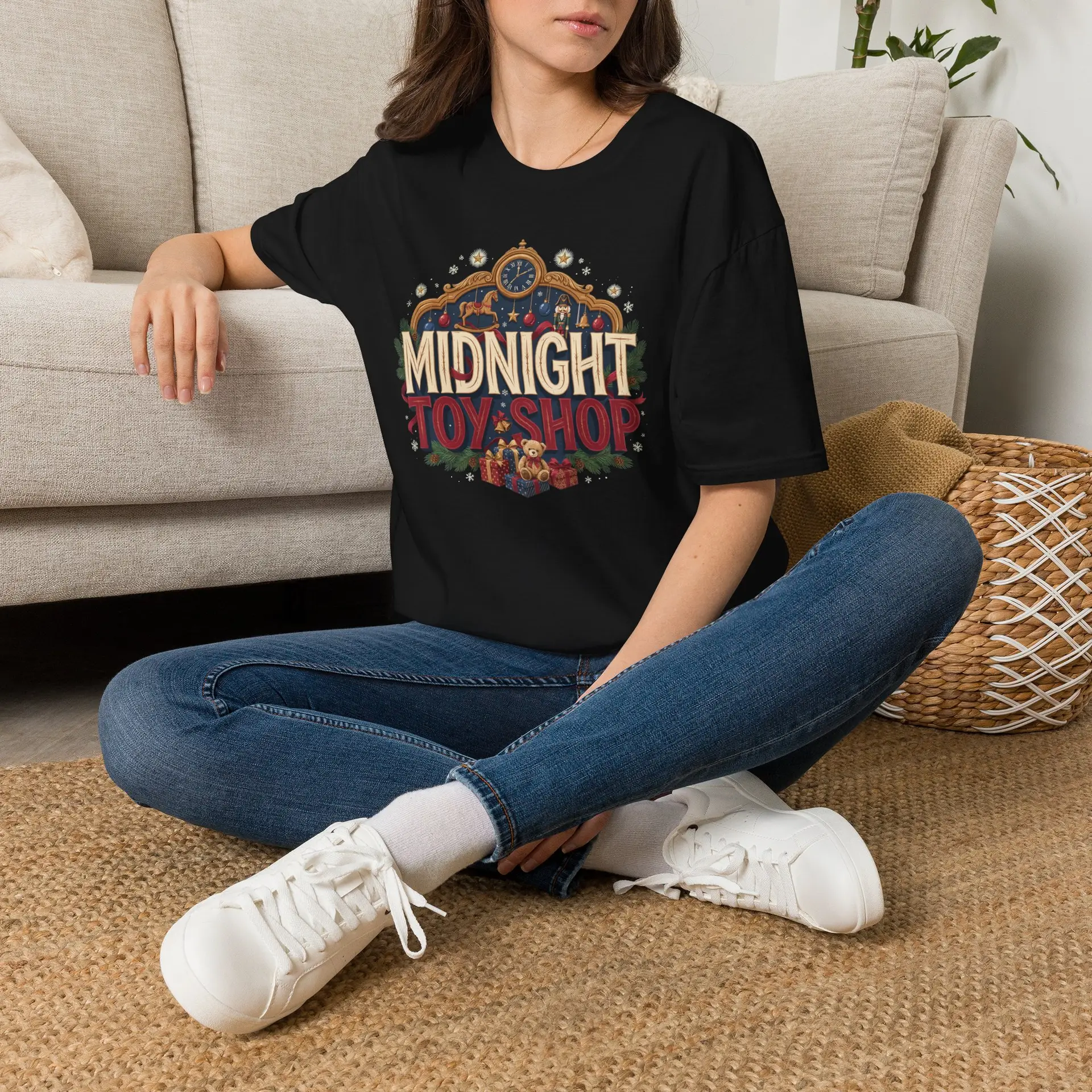 Woman wearing a black Midnight Toy Shop vintage Christmas graphic unisex t-shirt featuring retro holiday typography and festive toy store artwork while wearing a Santa hat in a white studio setting.