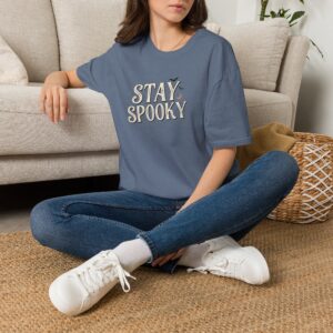 Model wearing a black Stay Spooky Halloween t-shirt featuring a retro script chest graphic with subtle Halloween accents.