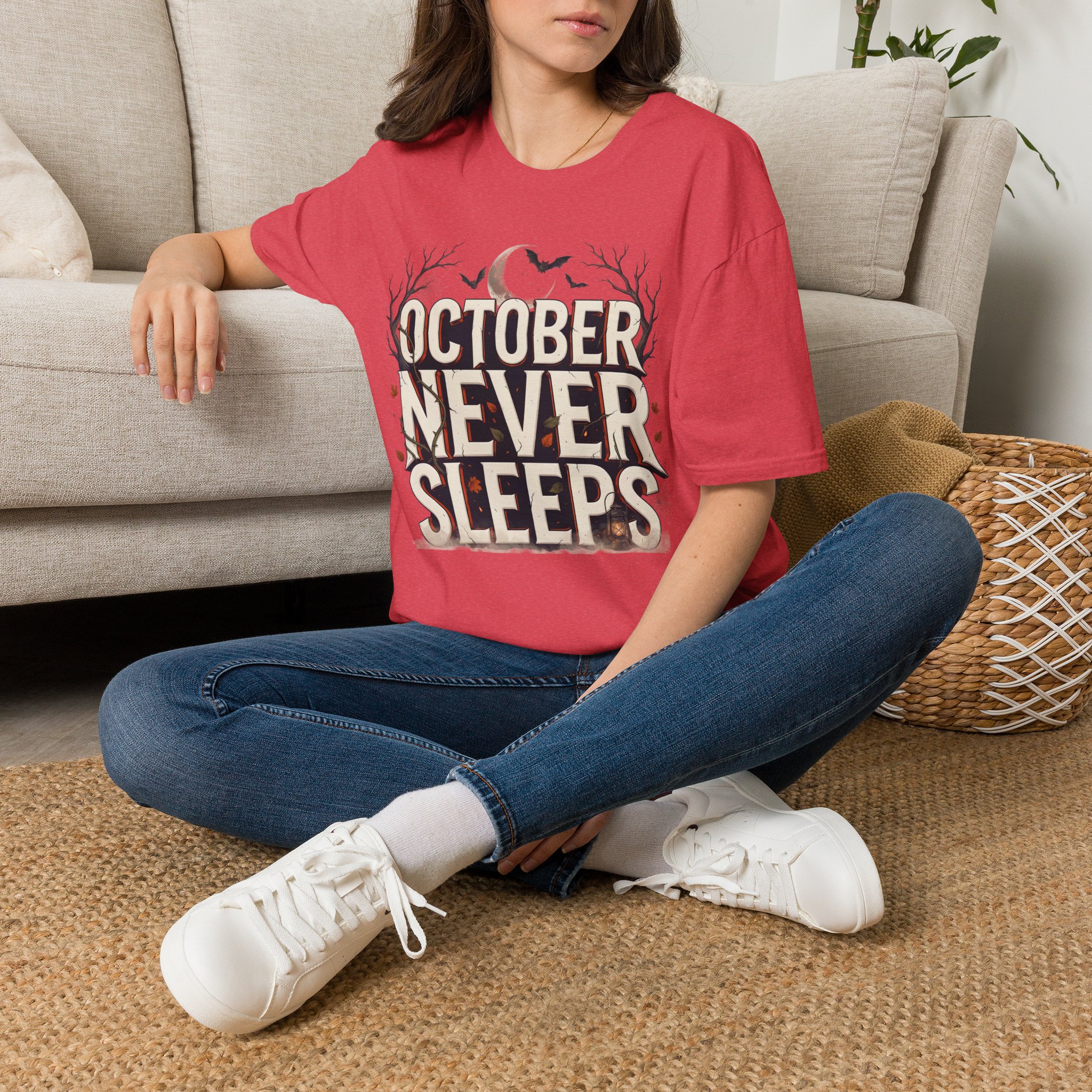 Woman wearing a purple October Never Sleeps Halloween graphic t-shirt featuring a vintage spooky typography design with moon, bats, and autumn tree silhouettes in a professional studio.