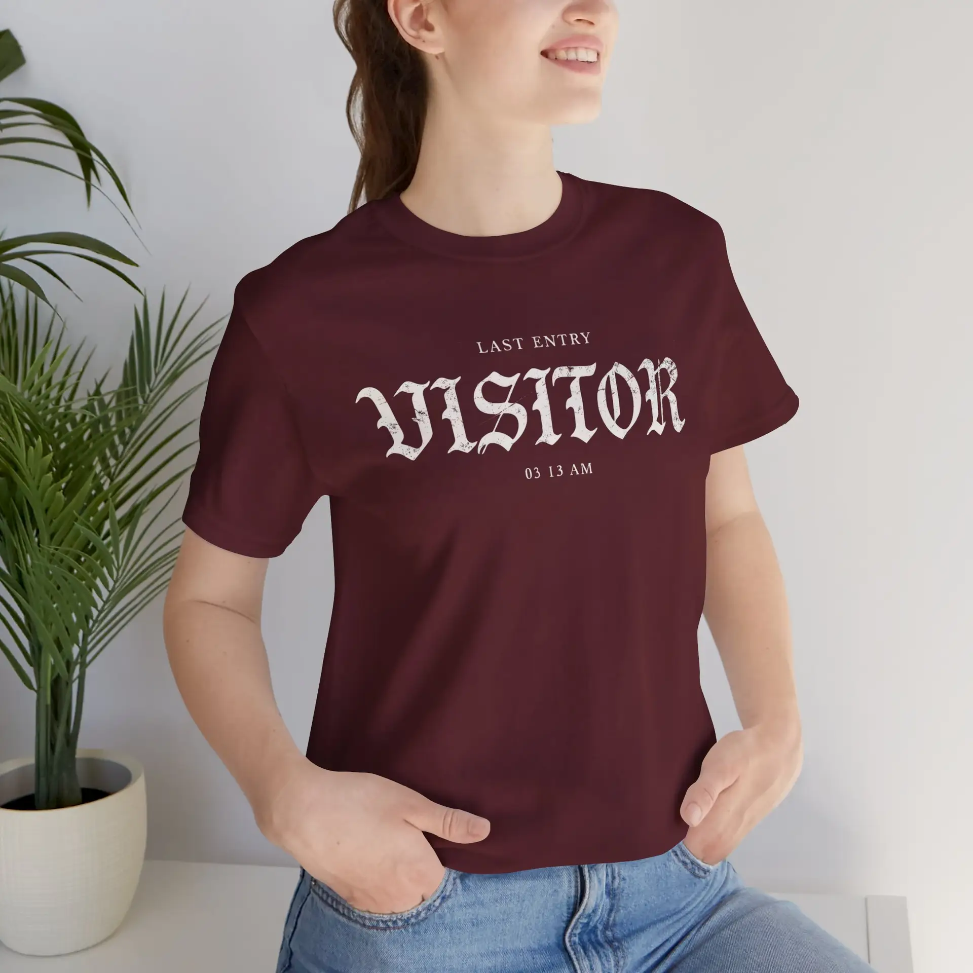 Image Alt Text (Front) Black Bella+Canvas 3001 unisex t-shirt featuring a vintage gothic "Visitor" front graphic with minimalist horror typography, modeled in a studio setting. Image Alt Text (Back) Back view of a black Bella+Canvas 3001 unisex t-shirt featuring "The Last Visitor" gothic horror back graphic with vintage typography and subtle distressed details, modeled in a studio setting.