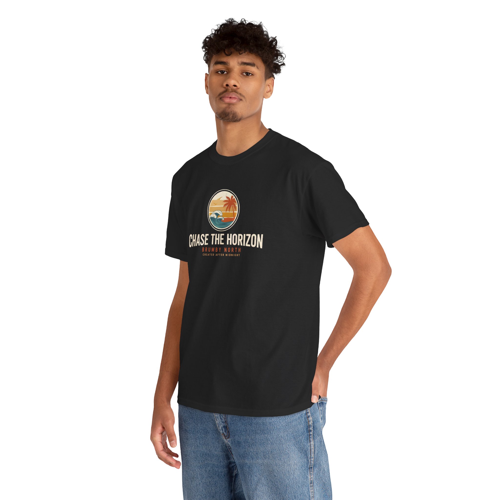 Woman wearing an olive green Chase The Horizon vintage surf graphic unisex heavy cotton t-shirt featuring a retro sunset chest print in a professional studio. Back Image Back view of woman wearing an olive green Chase The Horizon vintage surf graphic t-shirt with a large retro ocean wave and sunset illustration in a studio setting
