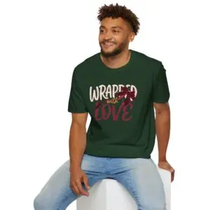 Woman wearing a black Wrapped with Love Christmas graphic t-shirt featuring festive typography with a holiday ribbon and gift bow design.