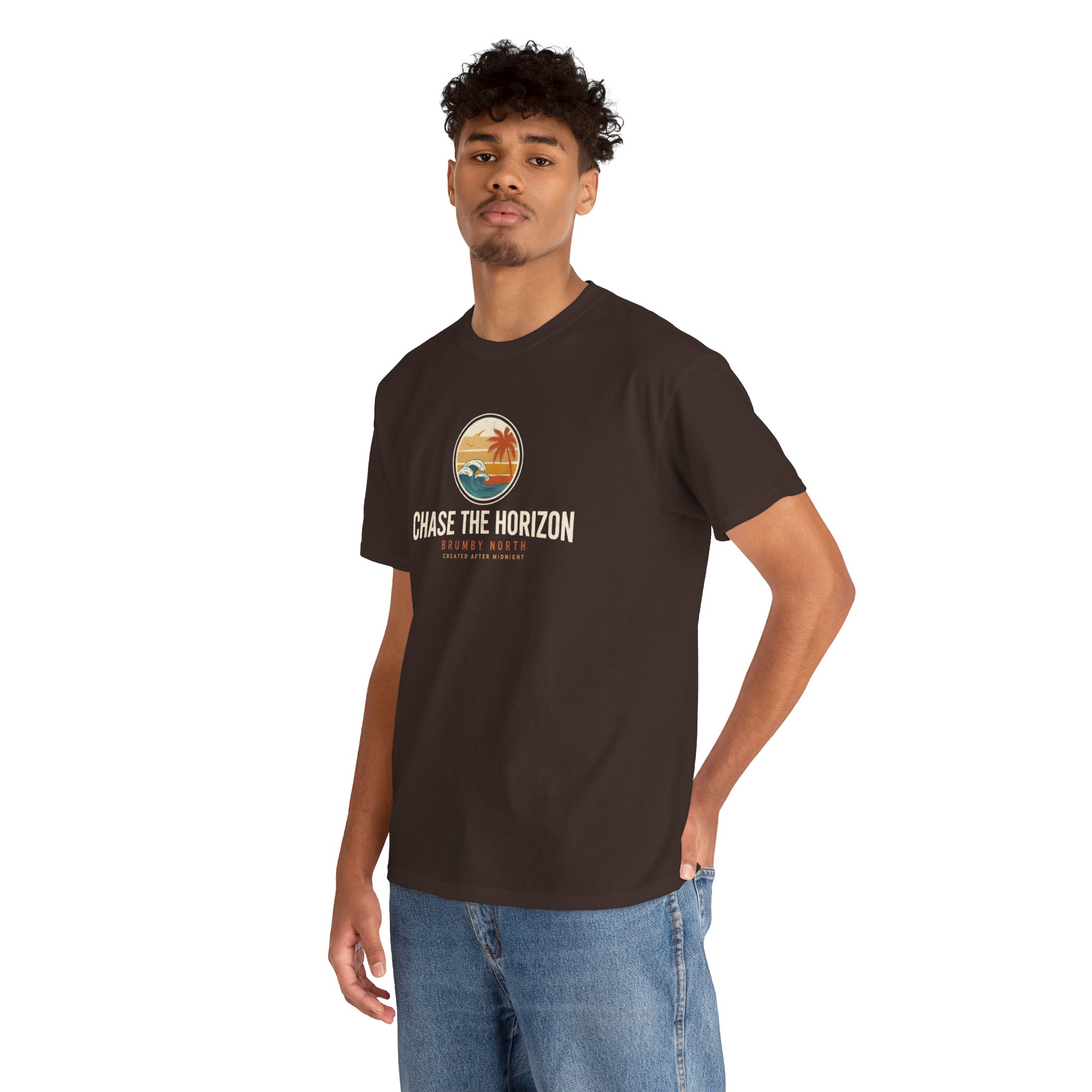 Woman wearing an olive green Chase The Horizon vintage surf graphic unisex heavy cotton t-shirt featuring a retro sunset chest print in a professional studio. Back Image Back view of woman wearing an olive green Chase The Horizon vintage surf graphic t-shirt with a large retro ocean wave and sunset illustration in a studio setting