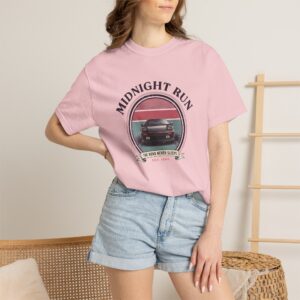 Person wearing a Midnight Run graphic t-shirt featuring a retro-inspired neon cityscape, classic late-night driving artwork, vibrant 90s color palette, and bold vintage typography, photographed in a professional studio.