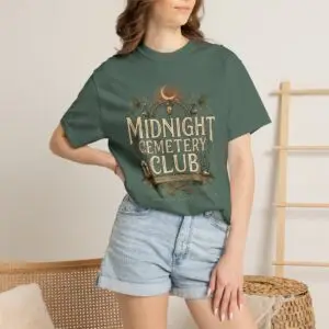 Front View Woman wearing a Comfort Colors Midnight Cemetery Club Halloween graphic t-shirt featuring vintage gothic typography, moonlit cemetery artwork, and a relaxed garment-dyed fit. Lifestyle Alt Text Premium Comfort Colors 1717 garment-dyed Halloween t-shirt with Midnight Cemetery Club vintage cemetery design, photographed on a female model in a casual lifestyle setting.