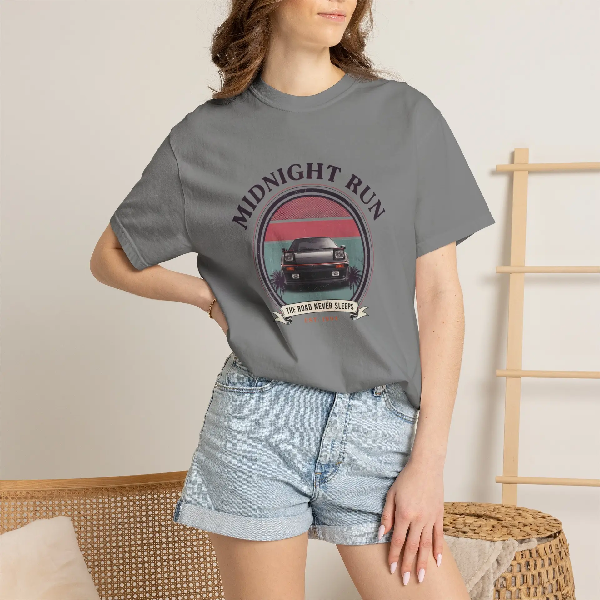 Person wearing a Midnight Run graphic t-shirt featuring a retro-inspired neon cityscape, classic late-night driving artwork, vibrant 90s color palette, and bold vintage typography, photographed in a professional studio.