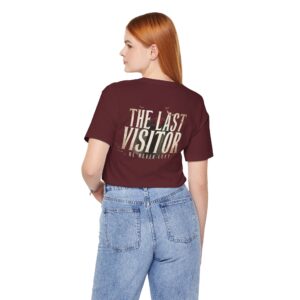 Image Alt Text (Front) Black Bella+Canvas 3001 unisex t-shirt featuring a vintage gothic "Visitor" front graphic with minimalist horror typography, modeled in a studio setting. Image Alt Text (Back) Back view of a black Bella+Canvas 3001 unisex t-shirt featuring "The Last Visitor" gothic horror back graphic with vintage typography and subtle distressed details, modeled in a studio setting.