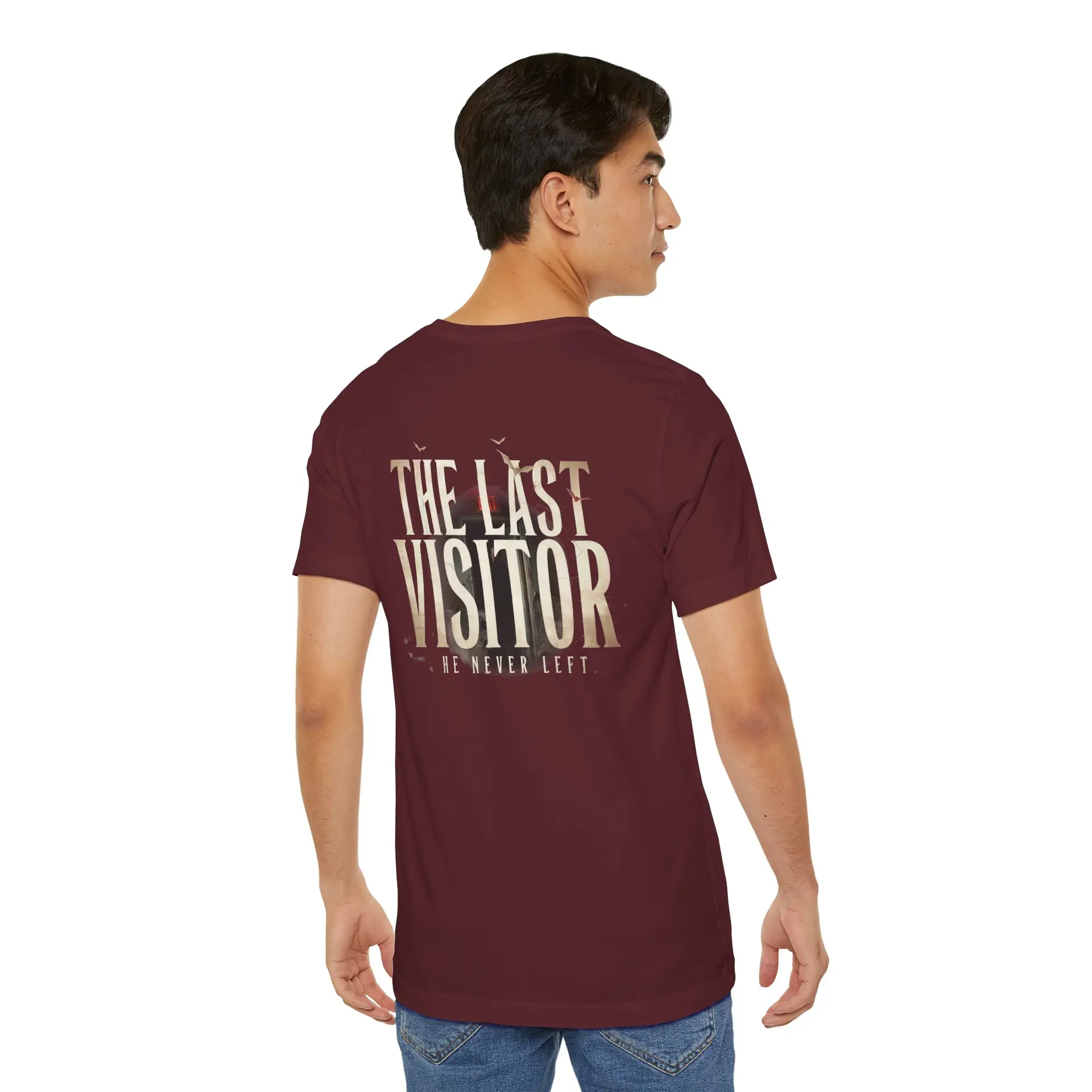 Image Alt Text (Front) Black Bella+Canvas 3001 unisex t-shirt featuring a vintage gothic "Visitor" front graphic with minimalist horror typography, modeled in a studio setting. Image Alt Text (Back) Back view of a black Bella+Canvas 3001 unisex t-shirt featuring "The Last Visitor" gothic horror back graphic with vintage typography and subtle distressed details, modeled in a studio setting.