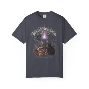 Comfort Colors 1717 black garment-dyed Halloween t-shirt featuring The Black Flame Society graphic with black cats, candles, purple flame, pumpkins, spell books, and witchy aesthetic artwork