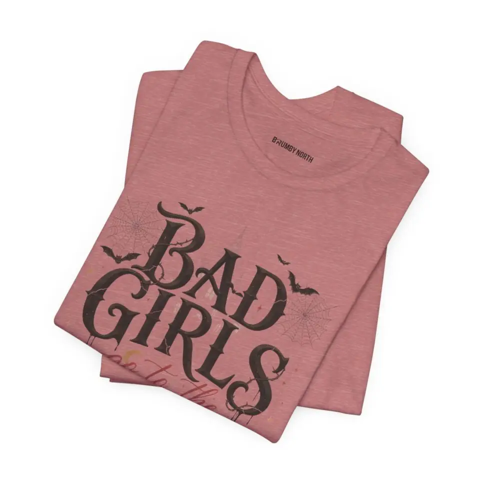 Front Mockup 1 Woman wearing the Bad Girls Go to the Haunted House Halloween graphic t-shirt featuring vintage typography, pumpkins, bats, and spiderweb artwork. Front Mockup 2 Cute Halloween graphic tee with "Bad Girls Go to the Haunted House" design on a premium Bella+Canvas 3001 t-shirt. Front Mockup 3 Women's spooky season t-shirt featuring vintage pumpkin artwork and playful Halloween typography. Front Mockup 4 Bella+Canvas Halloween t-shirt with gothic lettering, smiling jack-o'-lanterns, bats, and autumn floral details. Back Mockup 1 Back view of the Bella+Canvas 3001 Halloween graphic t-shirt showing the modern retail fit. Back Mockup 2 Rear view of the premium unisex Halloween t-shirt from Brumbynorth. Close-up 1 Close-up of the premium Halloween graphic print showing detailed typography, pumpkins, and bats. Close-up 2 Detailed close-up of the DTF printed Halloween artwork on soft Airlume combed ring-spun cotton