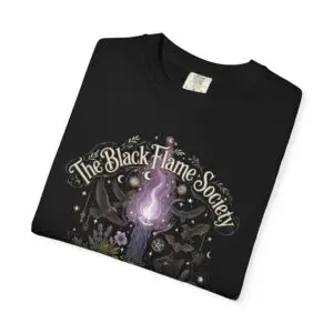 Comfort Colors 1717 black garment-dyed Halloween t-shirt featuring The Black Flame Society graphic with black cats, candles, purple flame, pumpkins, spell books, and witchy aesthetic artwork