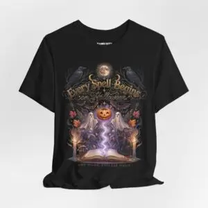 Woman wearing a black Bella+Canvas Halloween graphic t-shirt featuring a vintage illustration of an enchanted spell book, pumpkin, ghosts, candles, ravens, and the phrase "Every Spell Begins on Halloween."