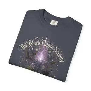 Comfort Colors 1717 black garment-dyed Halloween t-shirt featuring The Black Flame Society graphic with black cats, candles, purple flame, pumpkins, spell books, and witchy aesthetic artwork