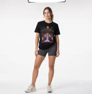 Woman wearing a black Bella+Canvas Halloween graphic t-shirt featuring a vintage illustration of an enchanted spell book, pumpkin, ghosts, candles, ravens, and the phrase "Every Spell Begins on Halloween."