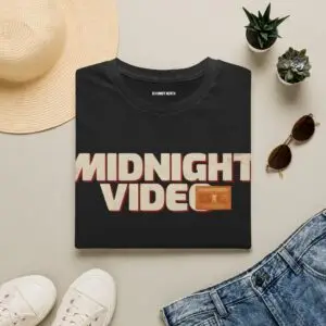 Midnight Video retro graphic unisex T-shirt in a studio Short Product Text Late-night video store nostalgia meets everyday streetwear. The Midnight Video T-Shirt features a retro-inspired graphic built around “MIDNIGHT VIDEO” and “RENT AFTER DARK.” SEO Keywords / Tags midnight video t-shirt, retro graphic tee, VHS t-shirt, vintage video store tee, retro streetwear, nostalgic graphic t-shirt, unisex graphic tee, retro movie shirt, casual streetwear, 90s inspired t-shirt, after dark graphic tee