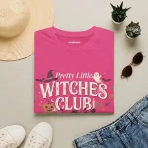 Pink Gildan Softstyle Halloween t-shirt featuring the "Pretty Little Witches Club" graphic with pumpkins, ghosts, bats, stars, and cute spooky fall artwork.