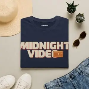 Midnight Video retro graphic unisex T-shirt in a studio Short Product Text Late-night video store nostalgia meets everyday streetwear. The Midnight Video T-Shirt features a retro-inspired graphic built around “MIDNIGHT VIDEO” and “RENT AFTER DARK.” SEO Keywords / Tags midnight video t-shirt, retro graphic tee, VHS t-shirt, vintage video store tee, retro streetwear, nostalgic graphic t-shirt, unisex graphic tee, retro movie shirt, casual streetwear, 90s inspired t-shirt, after dark graphic tee