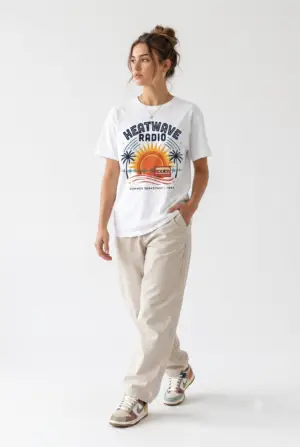 A vintage summer broadcast in T-shirt form. Heatwave Radio combines sunset colors, palm trees and retro radio graphics for an easygoing streetwear look.