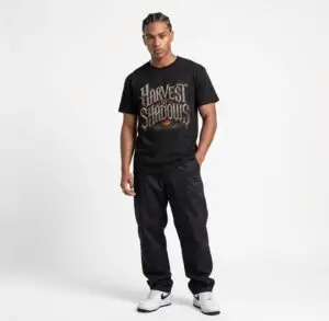Harvest of Shadows gothic Halloween pumpkin graphic unisex T-shirt Note: A model-specific alt text cannot be accurately written because no product/model image was provided with the information. Short Product Text A darker take on autumn streetwear, featuring cracked gothic lettering and a glowing jack-o’-lantern graphic. Harvest of Shadows is a lightweight unisex tee made for Halloween nights and everyday casual wear.