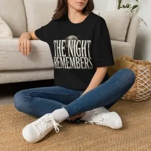 Front Mockup 1 The Night Remembers gothic moon graphic t-shirt featuring vintage typography, full moon, bats and haunted tree artwork. Front Mockup 2 Women's gothic Halloween graphic tee with The Night Remembers vintage moon design. Front Mockup 3 Vintage Halloween t-shirt with bold gothic typography and spooky moon artwork. Front Mockup 4 Dark aesthetic graphic t-shirt featuring The Night Remembers moon and haunted forest illustration. Back Mockup 1 Back view of The Night Remembers gothic Halloween t-shirt showing premium unisex fit. Back Mockup 2 Rear view of premium Gildan 64000 Halloween graphic tee from Brumbynorth. Close-up 1 Close-up of premium DTG printed gothic moon artwork on soft ring-spun cotton fabric. Close-up 2 Detailed close-up of The Night Remembers Halloween graphic showing crisp vintage typography and moon illustration.