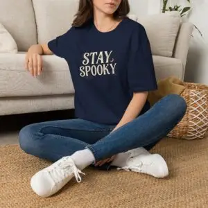 A black Stay Spooky Halloween t-shirt featuring a retro script chest graphic with subtle Halloween accents.