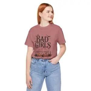 Front Mockup 1 Woman wearing the Bad Girls Go to the Haunted House Halloween graphic t-shirt featuring vintage typography, pumpkins, bats, and spiderweb artwork. Front Mockup 2 Cute Halloween graphic tee with "Bad Girls Go to the Haunted House" design on a premium Bella+Canvas 3001 t-shirt. Front Mockup 3 Women's spooky season t-shirt featuring vintage pumpkin artwork and playful Halloween typography. Front Mockup 4 Bella+Canvas Halloween t-shirt with gothic lettering, smiling jack-o'-lanterns, bats, and autumn floral details. Back Mockup 1 Back view of the Bella+Canvas 3001 Halloween graphic t-shirt showing the modern retail fit. Back Mockup 2 Rear view of the premium unisex Halloween t-shirt from Brumbynorth. Close-up 1 Close-up of the premium Halloween graphic print showing detailed typography, pumpkins, and bats. Close-up 2 Detailed close-up of the DTF printed Halloween artwork on soft Airlume combed ring-spun cotton
